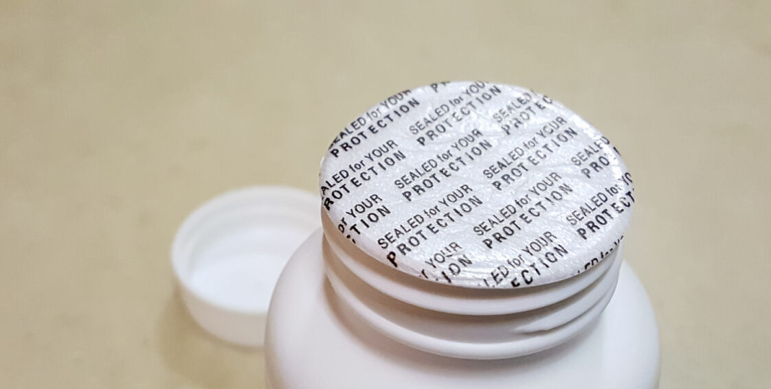 Protective tamper evident seal on top of white plastic bottle